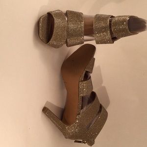 Strapped high heel sandals with sparkly gold mesh texture.